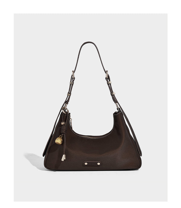 Crescent hobo shoulder bag in pebbled leather-look finish with top zipper, adjustable strap, gold-tone ring hardware, and