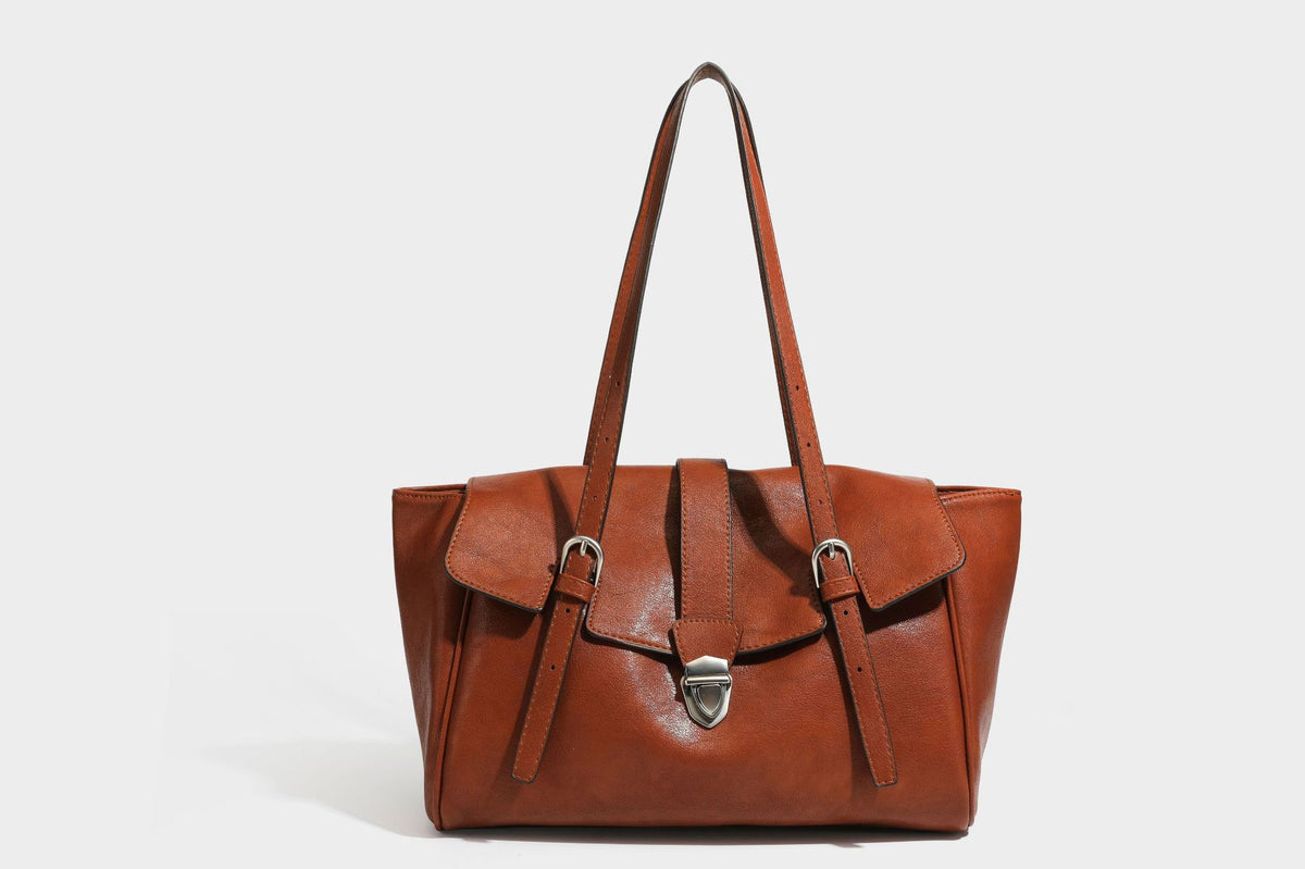 Large structured vintage-style tote bag with flap-front turn-lock closure, twin buckle straps, and double shoulder handles