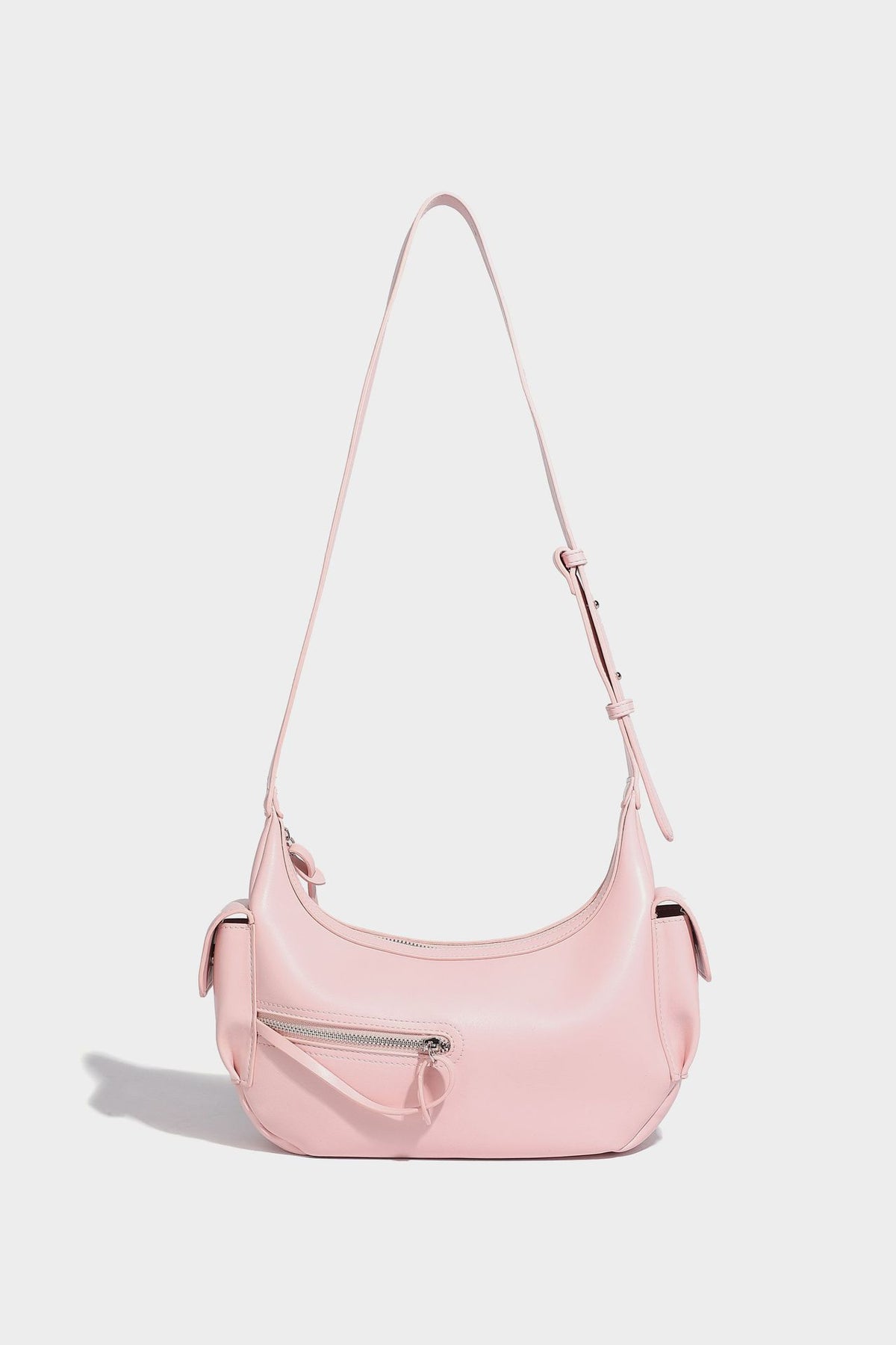 Smooth leather-look crescent shoulder bag with front zip pocket, side flap pockets, adjustable strap, and silver-tone, detail