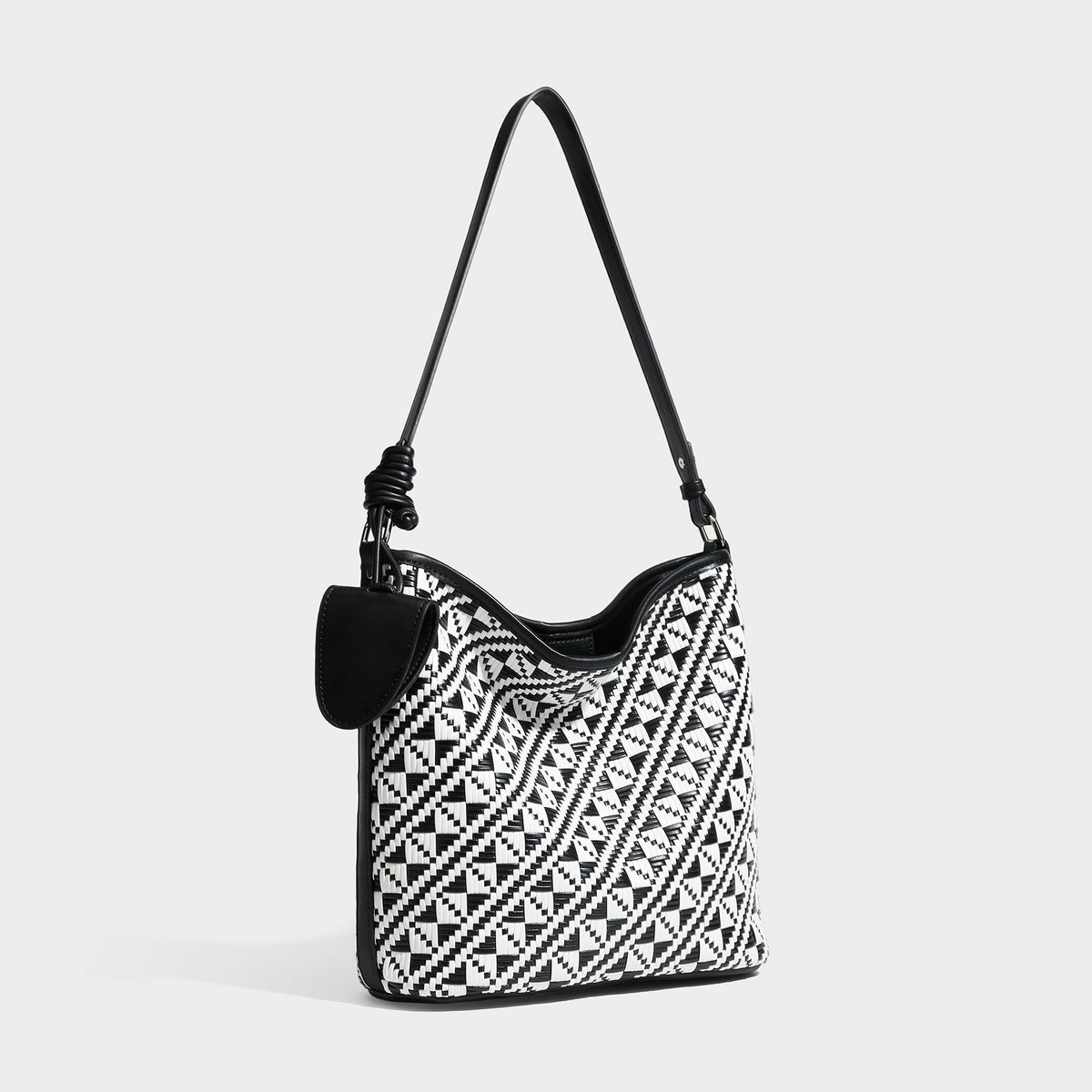 Geflochtene Schultertasche mit geometrischem Ethno-Muster, Besatz in dunkelbrauner Lederoptik, langem verstellbarem Träger und kleinem hängendem Reißverschluss