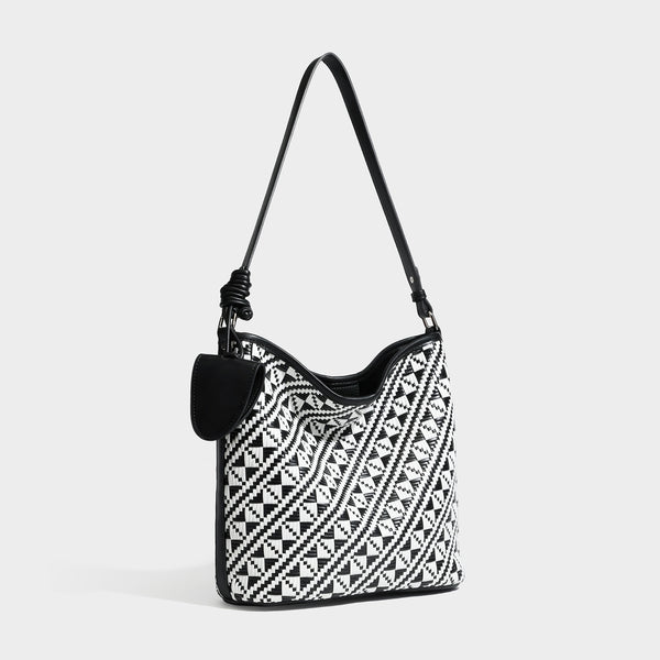 Geflochtene Schultertasche mit geometrischem Ethno-Muster, Besatz in dunkelbrauner Lederoptik, langem verstellbarem Träger und kleinem hängendem Reißverschluss
