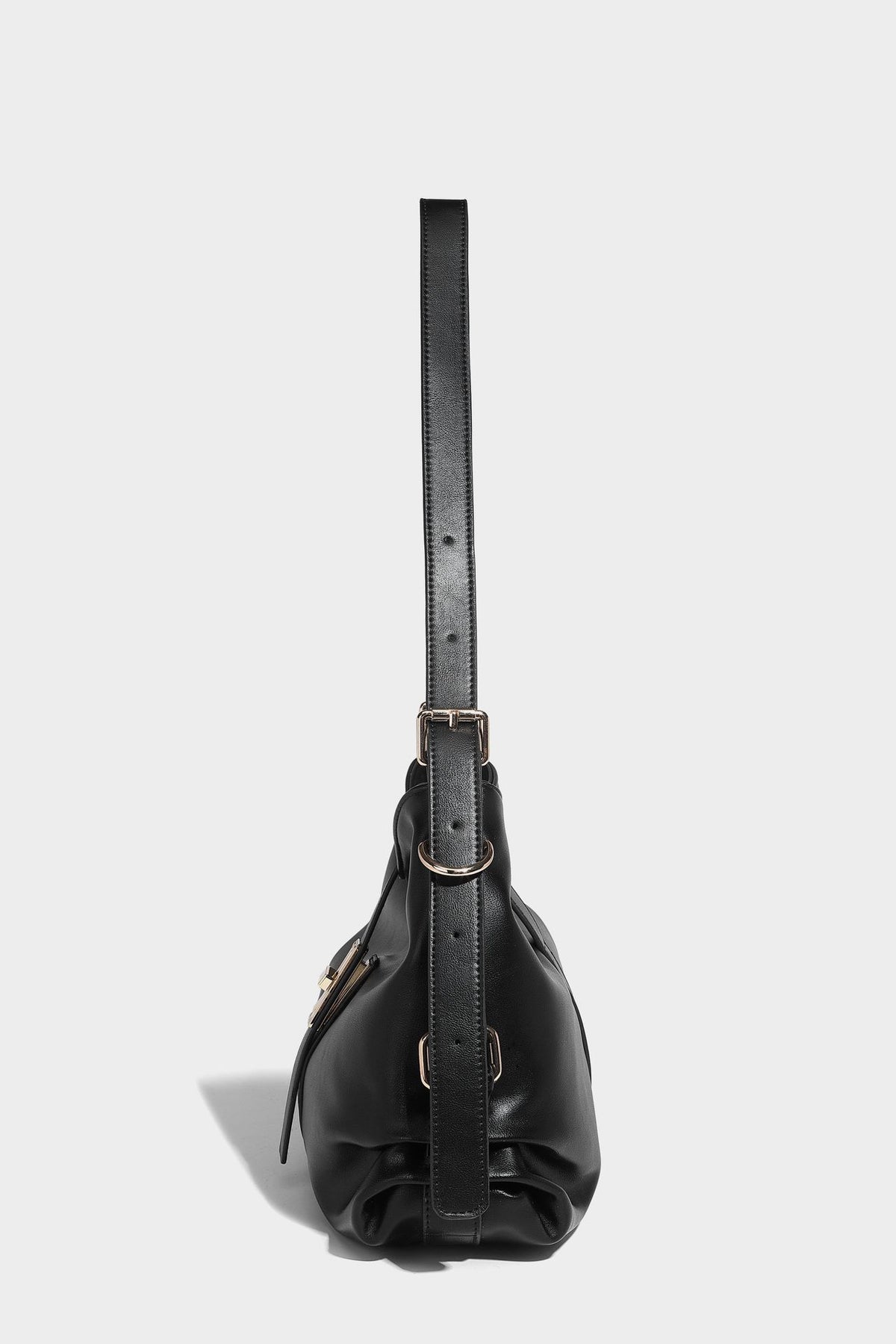 Soft slouchy hobo shoulder bag with smooth leather-look finish, gold-tone buckle and tab hardware, and long adjustable strap