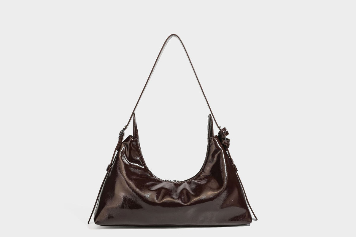 Glossy dark brown hobo shoulder bag with slim strap, front zip pocket, stud detail, and detachable leopard-print heart charm