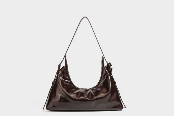 Glossy dark brown hobo shoulder bag with slim strap, front zip pocket, stud detail, and detachable leopard-print heart charm