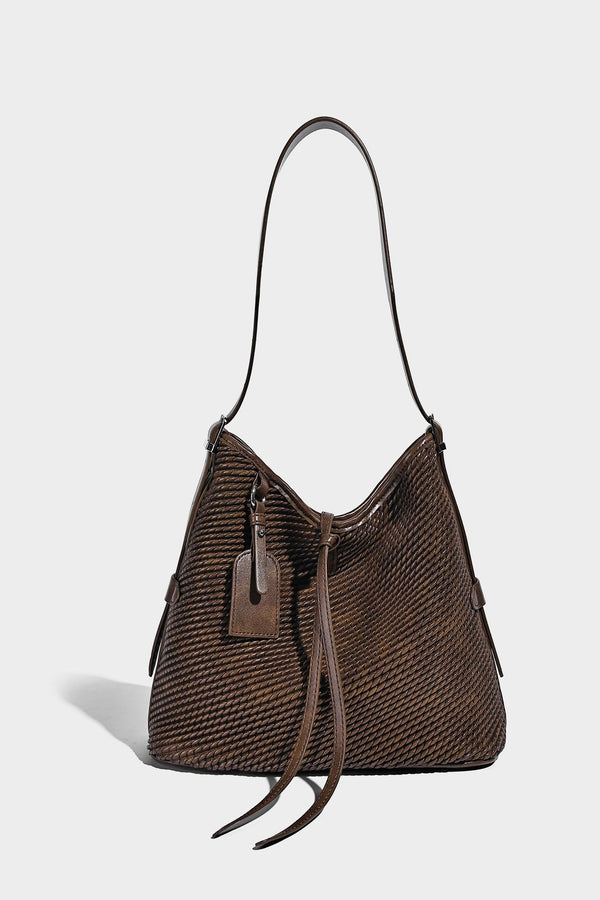 Große Schultertasche in Beutelform mit Flechtoptik, glatten Besätzen in Lederoptik, verstellbarem Riemen und hängendem Anhänger-Detail, Detailansicht