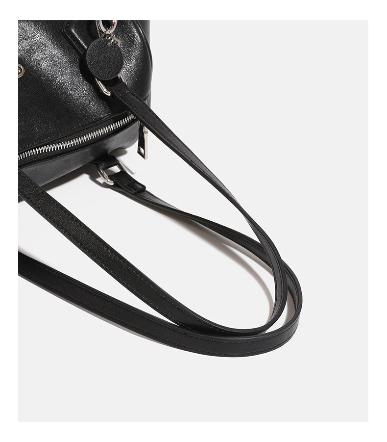 Schwarze Schultertasche in Lederoptik mit zylindrischer Form, silberfarbenen Reißverschlussbeschlägen, zwei flachen Tragegriffen, seitlicher Überschlagtasche und gewebtem Oliv