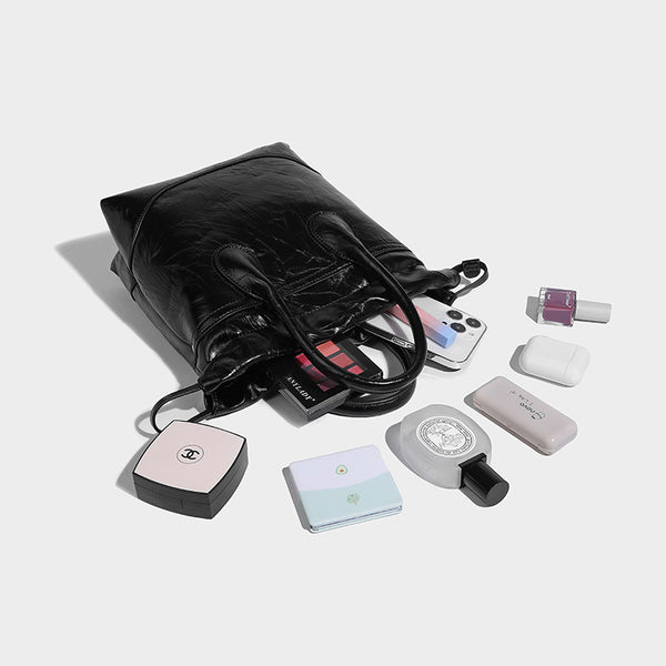 Glossy crinkled ruched drawstring bucket bag with rounded double top handles and detachable chain crossbody strap, detail