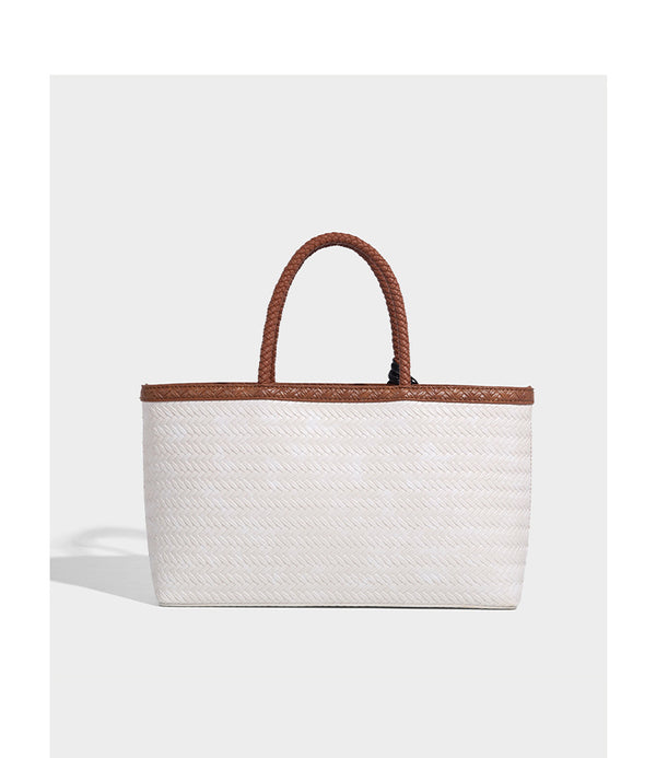 Structured woven-texture tote bag with brown braided top handles, decorative tassel charm, and detachable shoulder strap