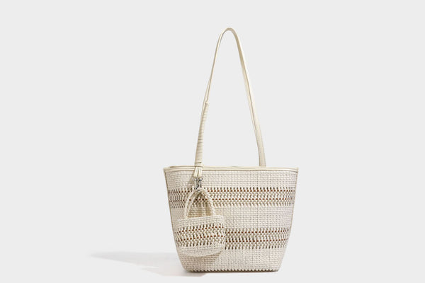 Large structured woven tote bag with striped basket-weave finish, long shoulder straps, and detachable mini pouch charm