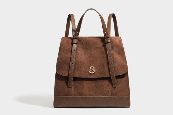 Structured suede-look convertible backpack handbag with flap closure and gold-tone emblem hardware in chocolate brown, detail