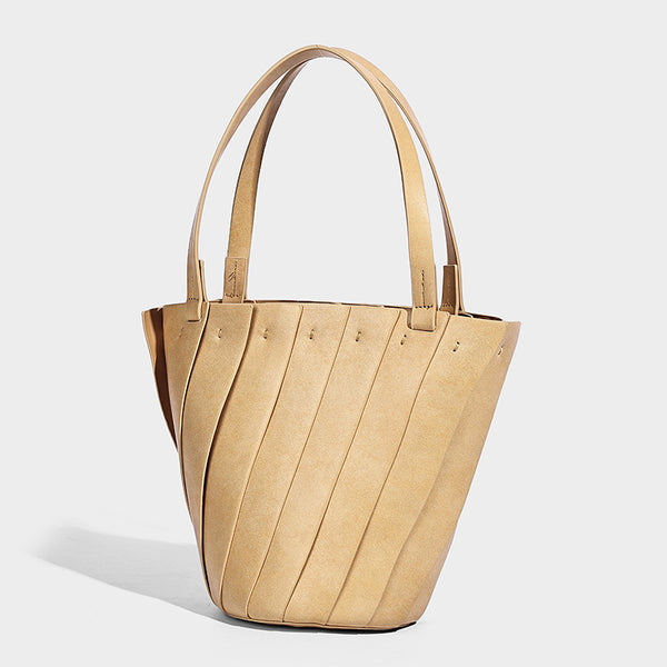 Structured bucket tote bag with vertical panel exterior, dual top handles, and detachable shoulder strap in tan leather-look