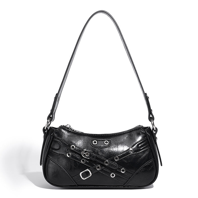 Compact moto-inspired shoulder bag with crisscross grommet strap detail, glossy textured finish, and adjustable crossbody