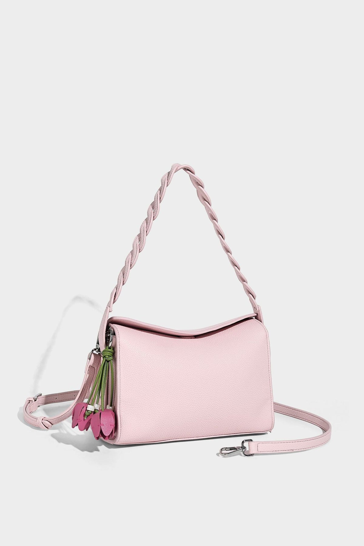 Small structured pebbled-finish shoulder bag with braided top handle, detachable crossbody strap, floral tassel charm, and