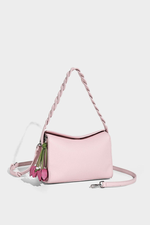 Small structured pebbled-finish shoulder bag with braided top handle, detachable crossbody strap, floral tassel charm, and