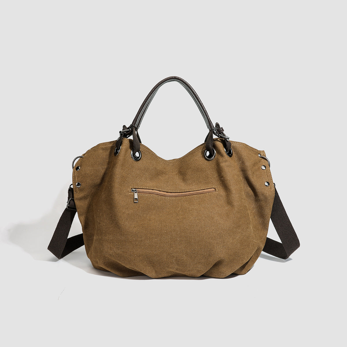 Slouchy matte canvas tote bag with dark dual top handles, metal grommet hardware, and detachable long shoulder strap, detail