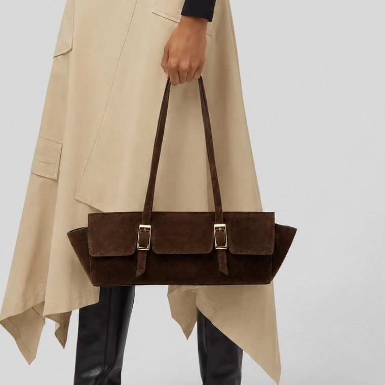 Wide trapezoid tote bag with matte suede-like finish, dual gold-tone buckle front pockets, and double flat shoulder straps