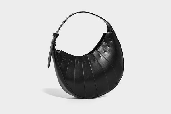 Crescent half-moon shoulder bag with vertical panel seaming, matte-satin leather-look finish, and adjustable gold-tone