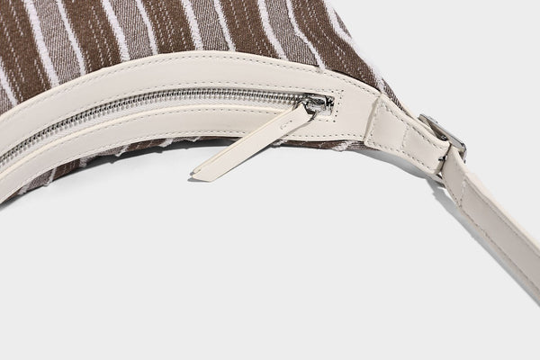 Lässig fallende, gestreifte gewebte Hobo-Bag mit kontrastierendem cremefarbenem Besatz, Reißverschluss oben und verstellbarem Riemen mit Schnalle in Silberoptik, Detailansicht