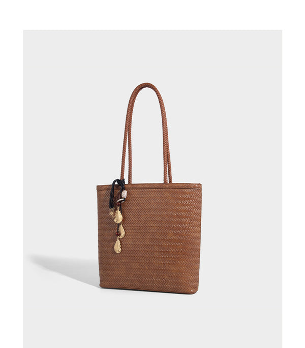 Structured woven herringbone tote bag with braided double shoulder handles in tan brown, shown with matching drawstring