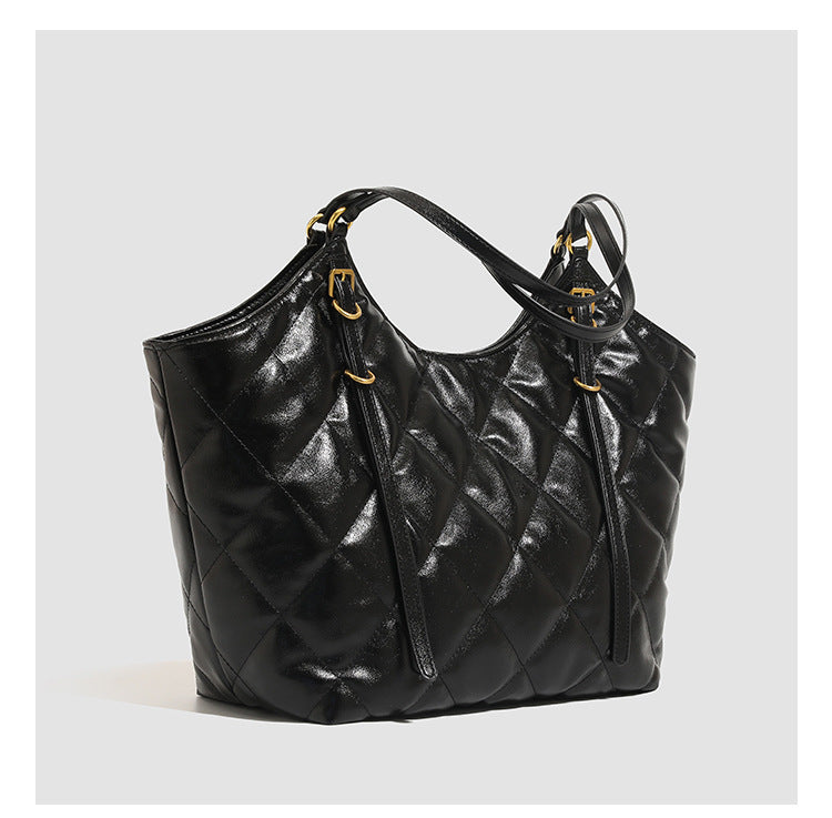 Large quilted diamond-pattern tote bag with glossy leather-look finish, dual flat shoulder straps, and gold-tone hardware