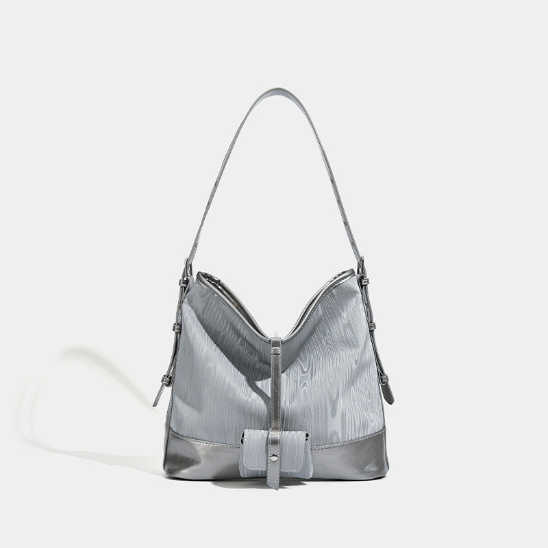 Silbergraue, weich fallende Hobo-Schultertasche mit holzmaserungsgeprägten Einsätzen, glänzenden Metallic-Details, Reißverschluss oben und vorderer Klappe, Vorderansicht