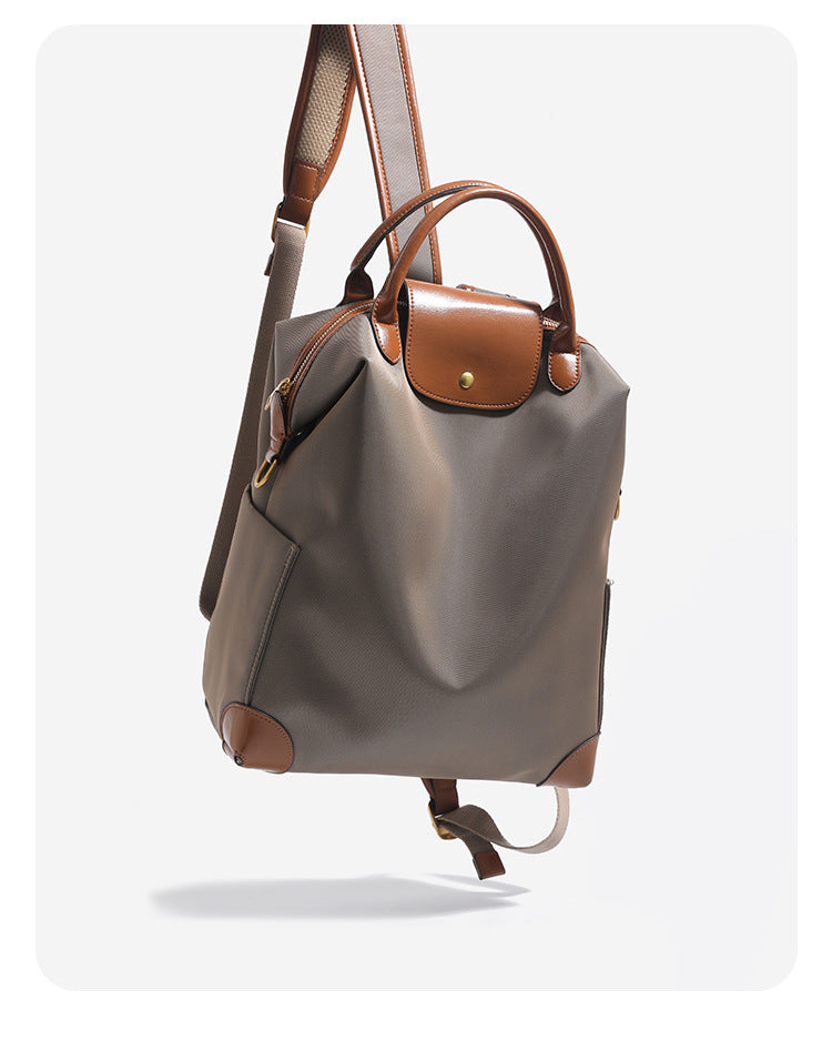 Large matte nylon backpack handbag with cognac leather-look trim, snap flap, and gold-tone hardware, detail view 9