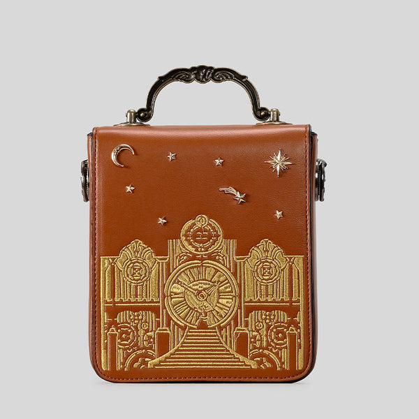 Small structured rectangular crossbody bag with ornate antique-style clock face and brass hardware in, detail view 2
