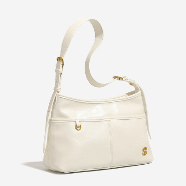 Relaxed leather-look shoulder tote bag in cream white with front exterior pocket, gold-tone ring hardware, and adjustable