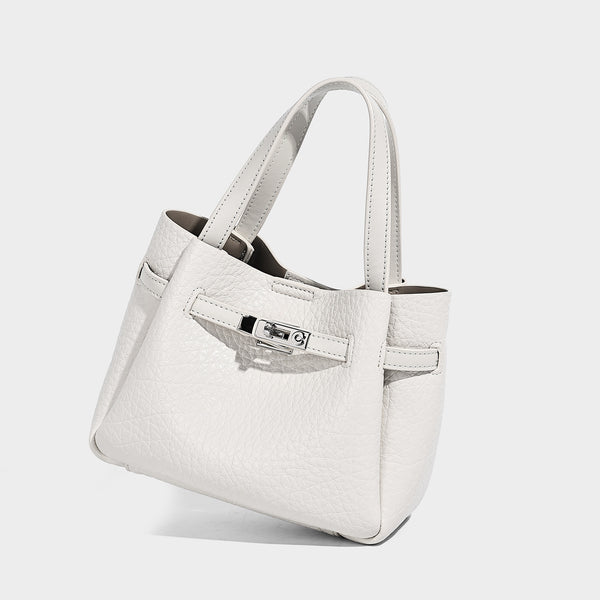 Small structured pebbled bucket tote with double top handles, silver turn-lock hardware, and detachable shoulder strap