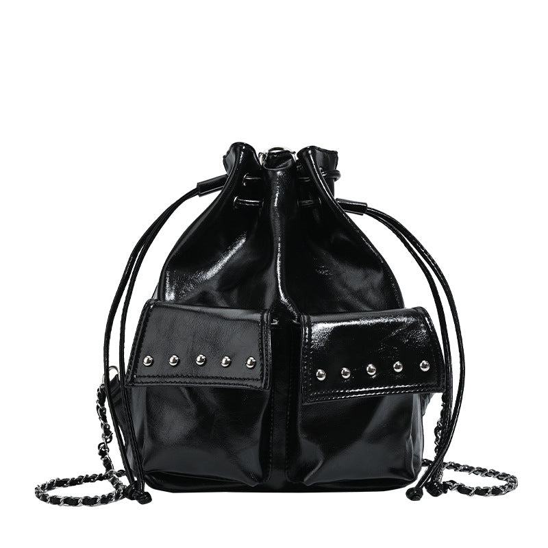 Glossy leather-look drawstring bucket bag with silver dome studs and chain shoulder strap, detail view 5
