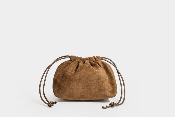 Pebbled leather-look bucket tote bag with rolled double handles, drawstring closure, braided cord charm, and detachable