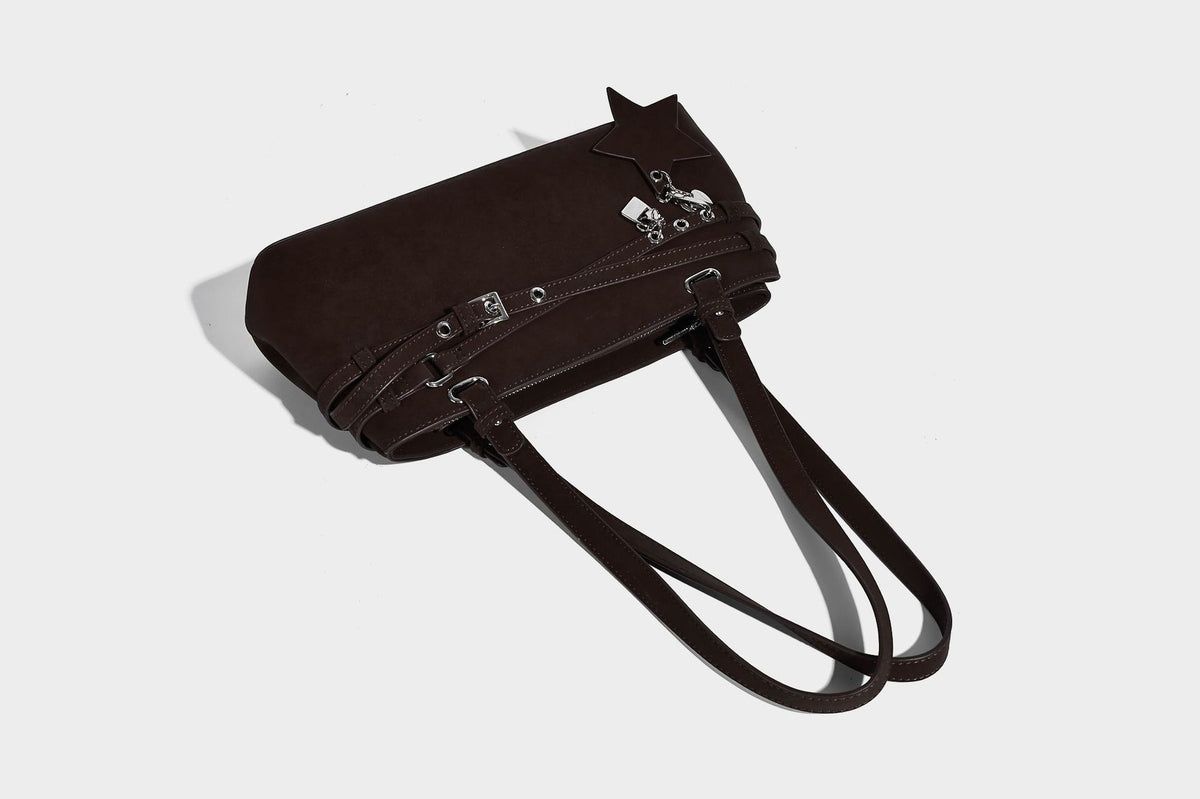Structured trapezoid shoulder tote in dark brown matte suede-look finish with dual straps, wraparound belt bands