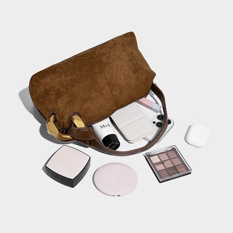 Kompakte Boston-Schultertasche in warmer, brauner Veloursleder-Optik mit glattem dunkelbraunem Besatz, übergroßem goldfarbenem Ringbeschlag und Reißverschluss oben
