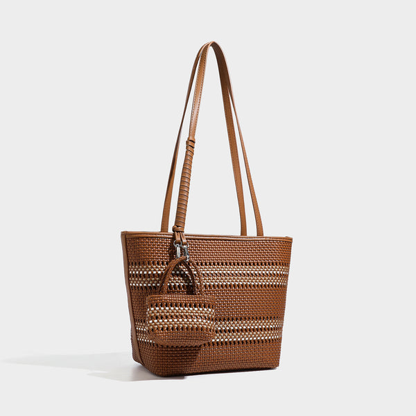Large structured woven tote bag with striped basket-weave finish, long shoulder straps, and detachable mini pouch charm