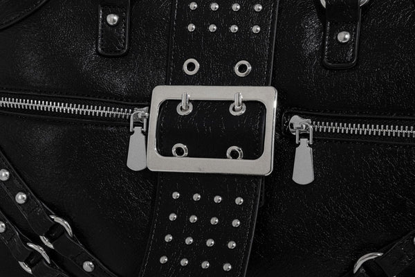 Schwarze, glänzende Henkeltasche mit genarbter Struktur, silberfarbenen Nieten, Riemendetail mit Schnalle, zwei Henkeln und breitem, mit Nieten besetztem Schulterriemen