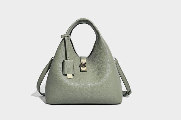 Structured pebbled-texture bucket bag with arched top handles, gold-tone turn-lock closure, and detachable shoulder strap