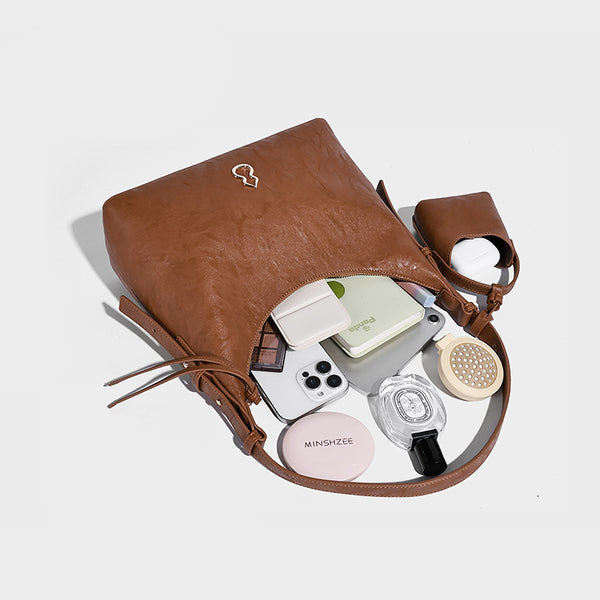Glänzende Hobo-Schultertasche in Lederoptik mit abnehmbarem Mini-Beutel und goldfarbenen Logo-Details, Detailansicht 4