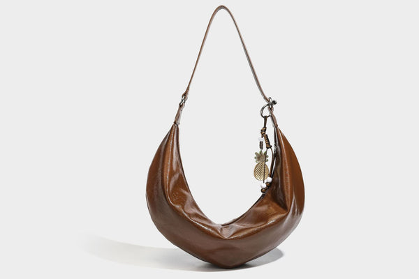 Lässig fallende Hobo-Schultertasche in Halbmondform mit glänzender, geknautschter Lederoptik, schmalem Riemen, silberfarbenen Ringbeschlägen und