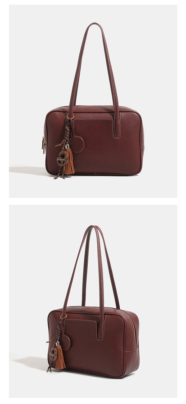 Structured rectangular leather-look shoulder bag with top zip, tassel and resin ring charm, and contrast topstitching, detail