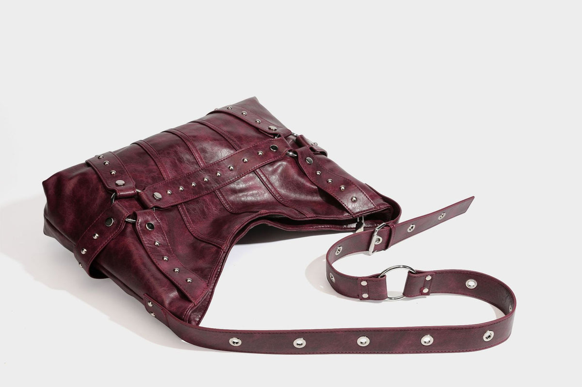 Lässige Hobo-Schultertasche in glänzender Lederoptik mit silberfarbenen Nieten, Riemendetail mit Schnalle und Reißverschluss oben