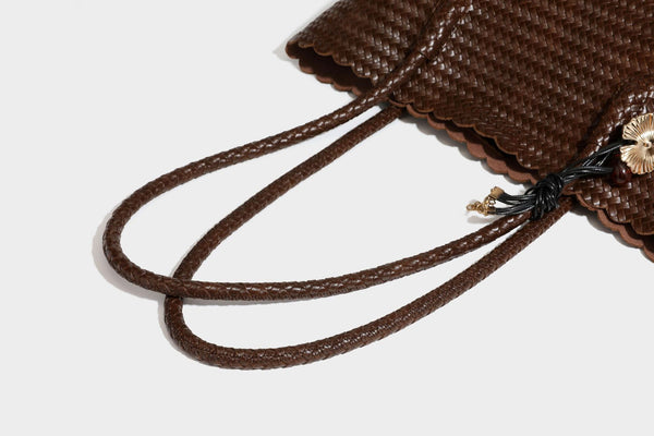 Large open-top woven leather-look tote bag in dark brown with scalloped edge, braided double shoulder straps, and decorative