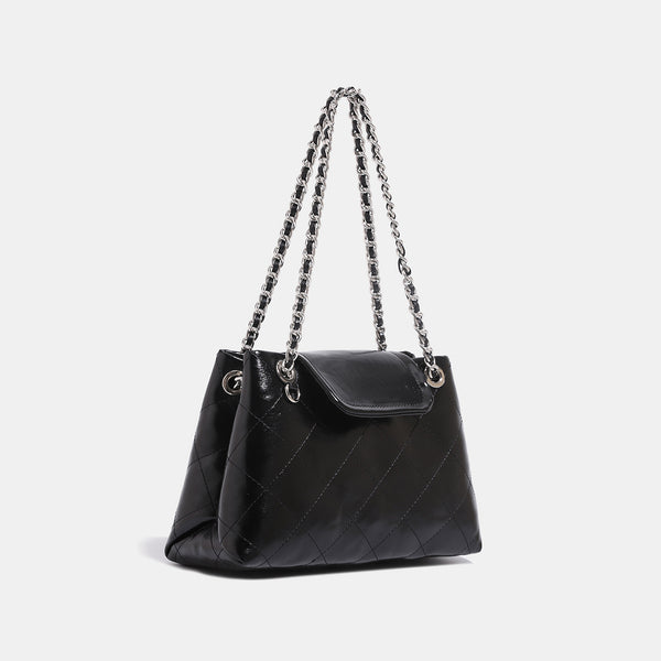 Quilted trapezoid shoulder bag with chain straps, flap closure, and ring hardware, detail view 3
