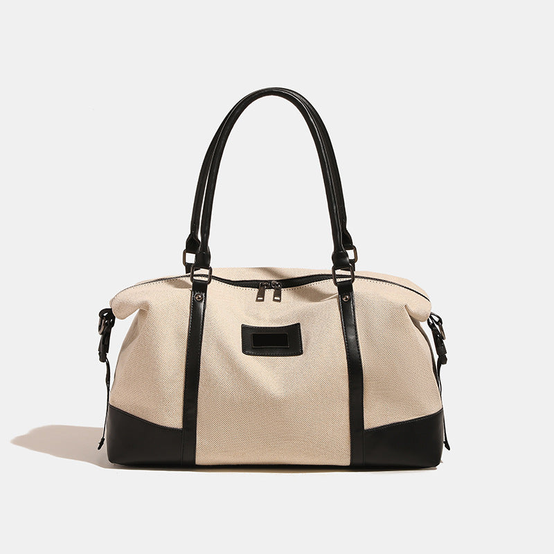 Large cream canvas tote bag with dark leather-look trim, dual top handles, and detachable shoulder strap, detail view 6