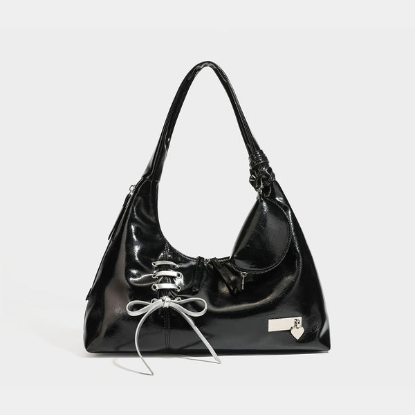 Weich fallende Hobo-Schultertasche mit glänzender Oberfläche in Lederoptik, silberfarbenen Schnürringösen und Schleife aus Ripsband auf der Vorderseite, Detail