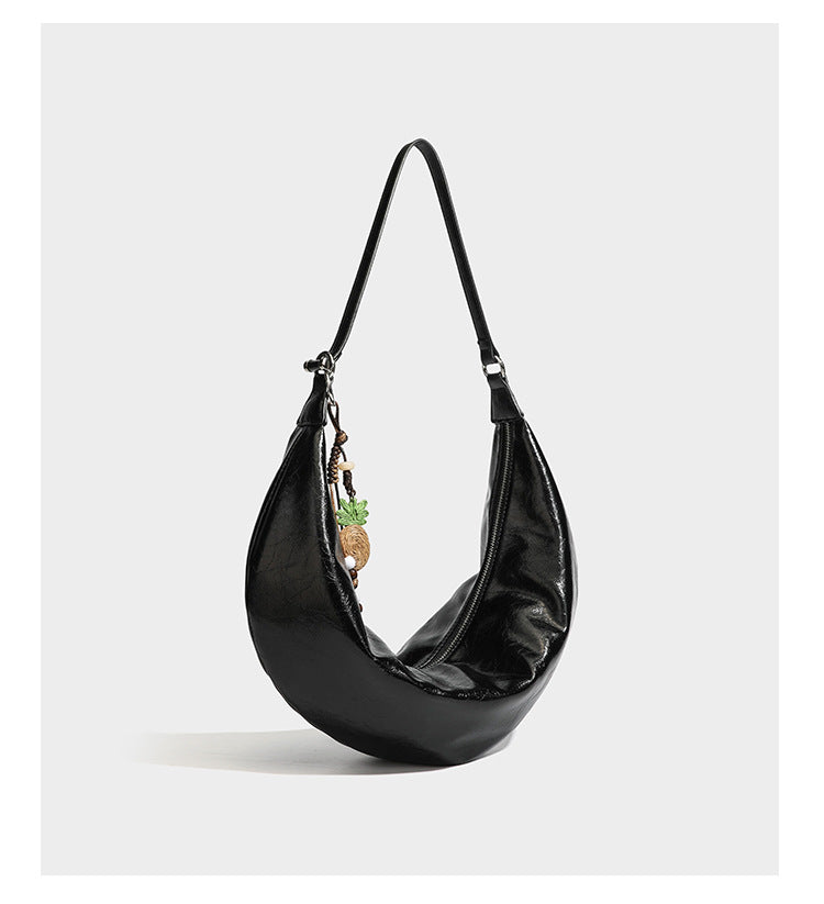 Lässig fallende Hobo-Schultertasche in Halbmondform mit glänzender, geknautschter Lederoptik, schmalem Riemen, silberfarbenen Ringbeschlägen und
