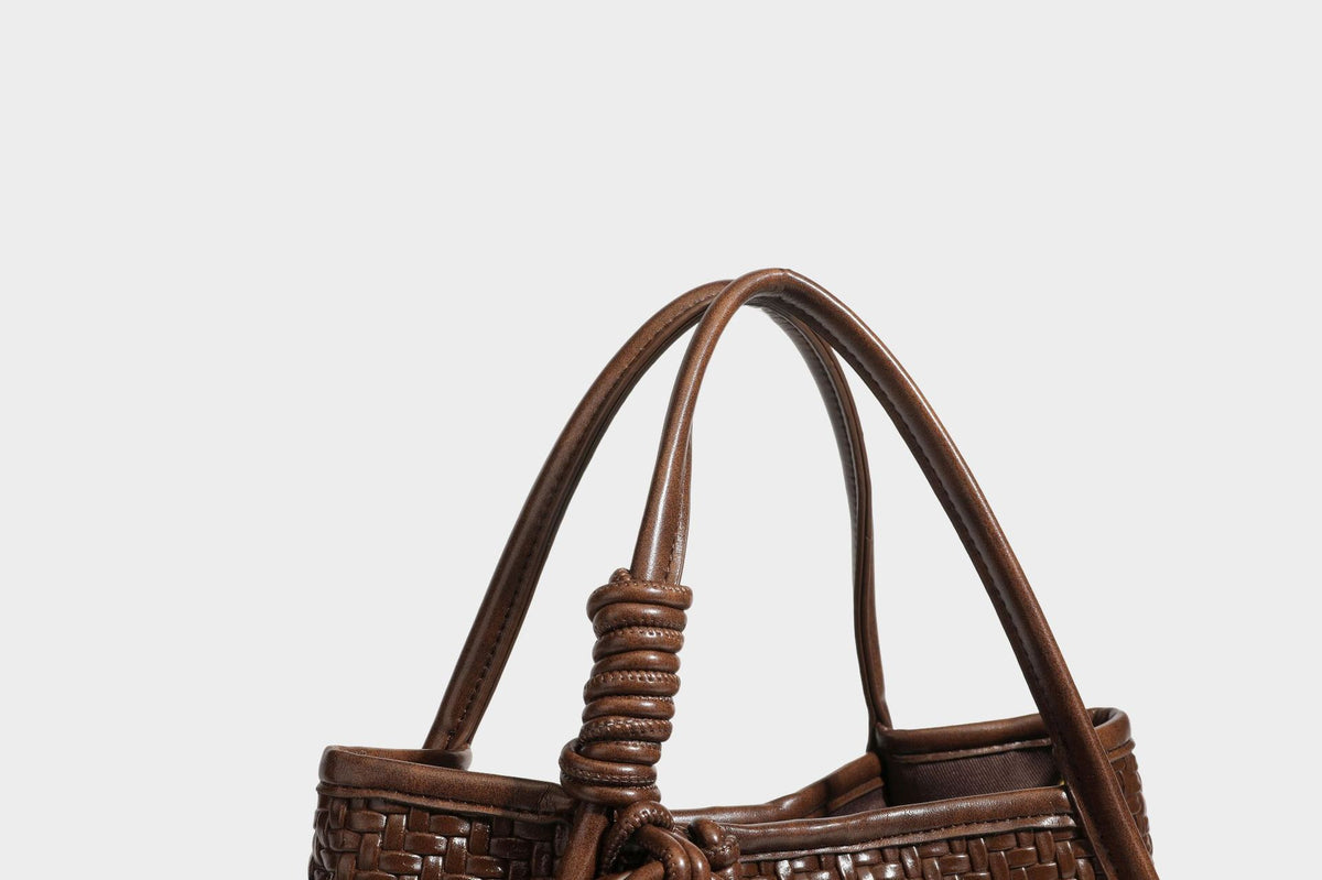 Strukturierte Tote-Bag mit Webstruktur in Braun, glattem, lederähnlichem Besatz, geknoteten Tragegriffen und einer befestigten Mini-Beuteltasche mit Kordelzug