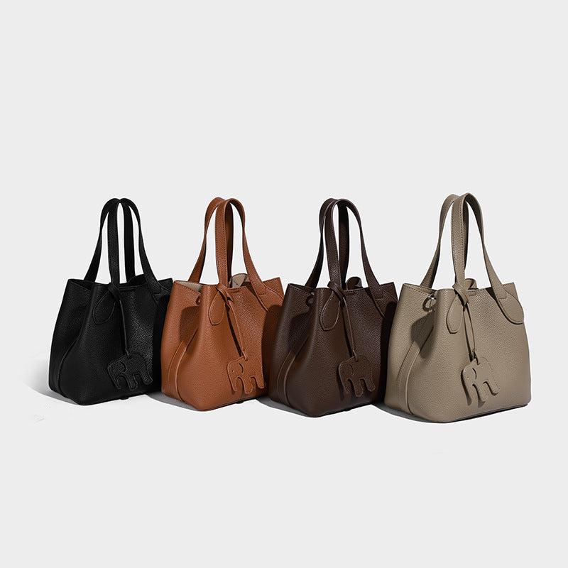Compact pebbled bucket tote bag with elephant charm, twin top handles, and detachable crossbody strap, detail view 2