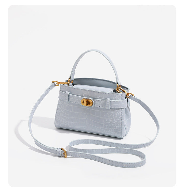 Small structured crocodile-embossed top-handle bag with gold-tone turn-lock closure and detachable shoulder strap, detail