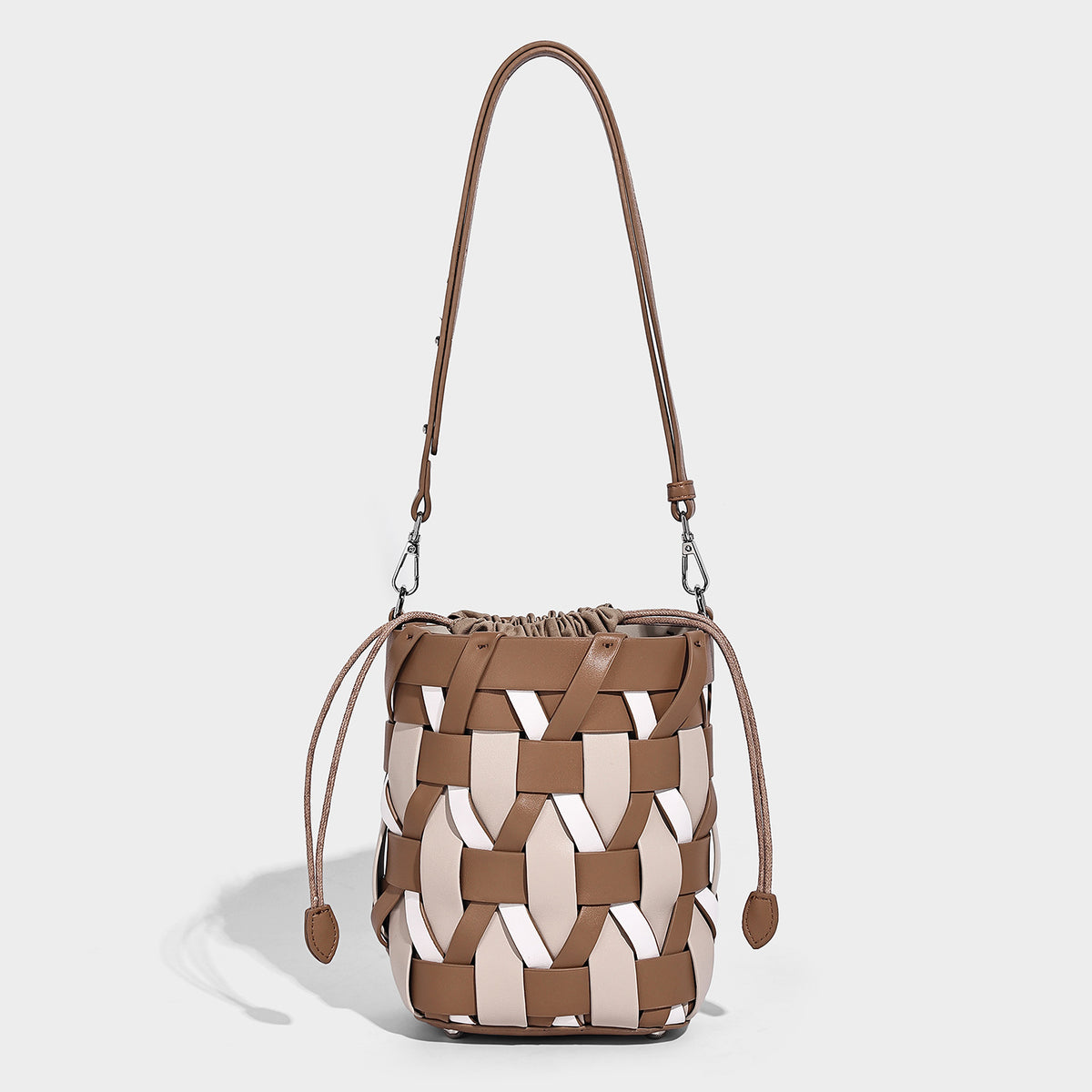 Small woven lattice bucket bag in tan and cream leather-look strips with drawstring top and detachable crossbody strap, front