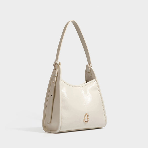 Strukturierte Trapez-Schultertasche mit glänzender, geknitterter Oberfläche in Lederoptik, goldfarbenen Beschlägen an der Vorderseite und langem, verstellbarem